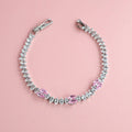 Silver bracelet with pink and clear zirconia stones on pink background