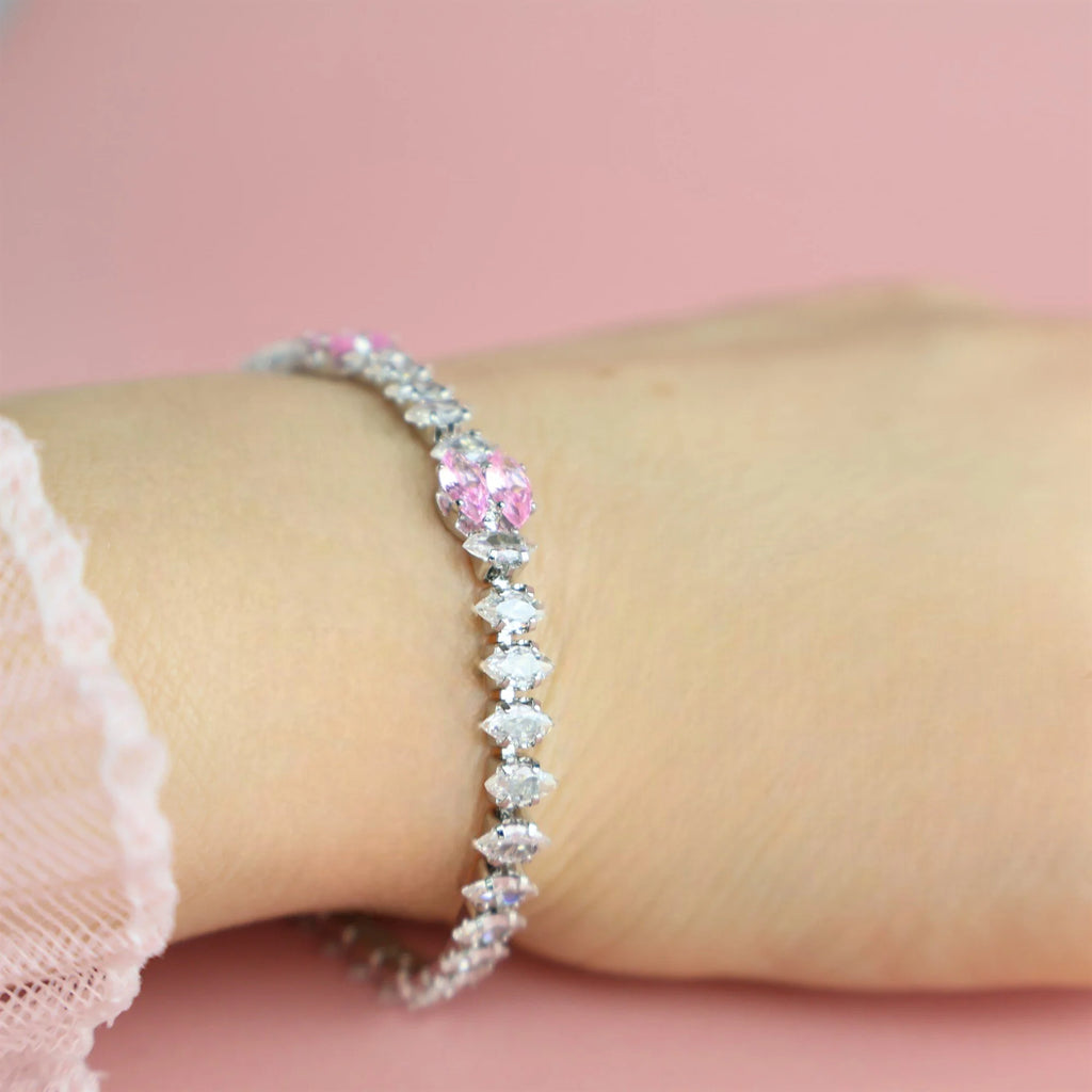 Dainty silver tennis bracelet with pink accents styled on hand
